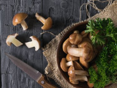 Tahta bir masa üzerinde çuval bir parça üzerinde dilimlenmiş mantar Butters ile Kase.