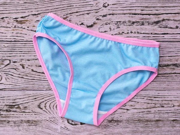 Women's panties are blue with a pink stripe on a pink wooden background. Fashionable concept. Beautiful lingerie. The view from the top. — Stock Photo, Image