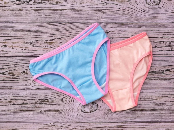 Blue on top of pink panties on a wooden background. Fashionable concept. Beautiful lingerie. The view from the top. — Stock Photo, Image