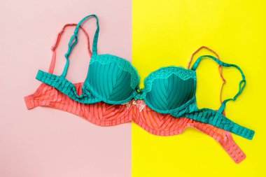 Sarı ve pembe arka planda kırmızı üzerinde yeşil sutyen. Düz yatma.