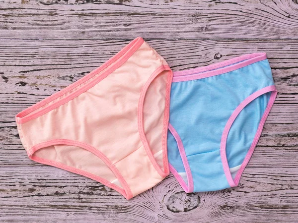 Pink women's panties on top of the blue on a wooden background. Fashionable concept. Beautiful lingerie. The view from the top. — Stock Photo, Image