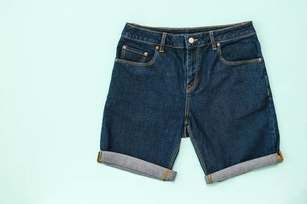 Blaue Jeans-Shorts auf blauem Hintergrund. Modische Unisex-Kleidung. — Stockfoto