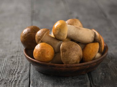 Ahşap bir masa üzerinde kil bir kapta Orman mantar.