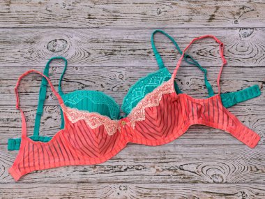 Ahşap arka plan üzerinde yeşil üzerinde kırmızı sütyen.