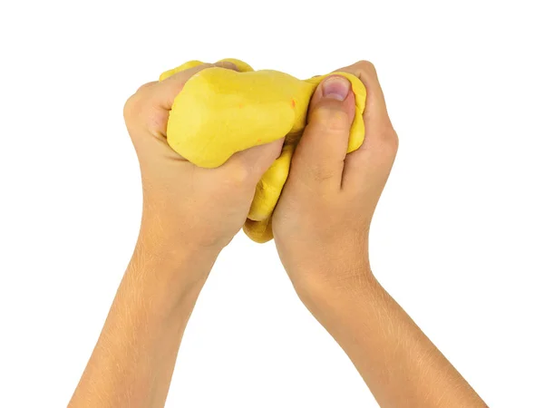 The child's hands knead the yellow slime isolated on a white background. — Stock Photo, Image