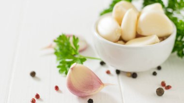 Beyaz bir masada biber ve otlar ile Sarımsak karanfil. Geleneksel tıbbın bileşeni.