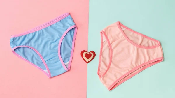 Blue and pink panties and red heart on blue and pink background. The concept of meeting lovers. Underwear. The view from the top. — Stock Photo, Image