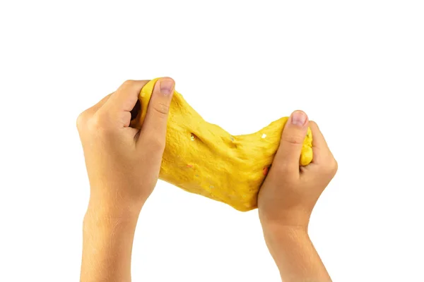 Stretched yellow slime in baby\'s hands isolated on white background.