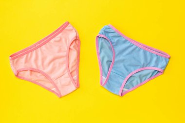 Sarı arka planda renkli kadın külot. Aşıklar buluşma kavramı. Iç çamaşırı. Yukarıdan görünüm.