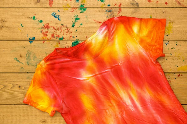 T-shirt boyama için ahşap bir masa üzerinde kravat boya tarzında boyanmış. Düz yatıyordu.