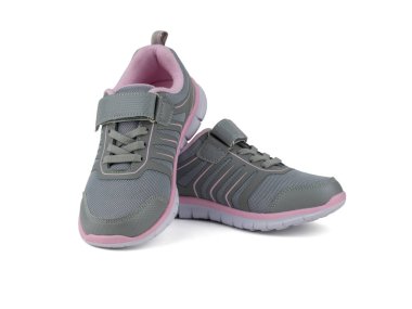 Beyaz arka planda izole kırmızı kenarlıklı modaya uygun gri spor ayakkabılar.