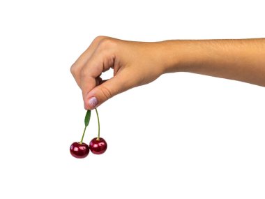 Beyaz bir arka plan üzerinde izole bir çocuğun elinde iki olgun kiraz.