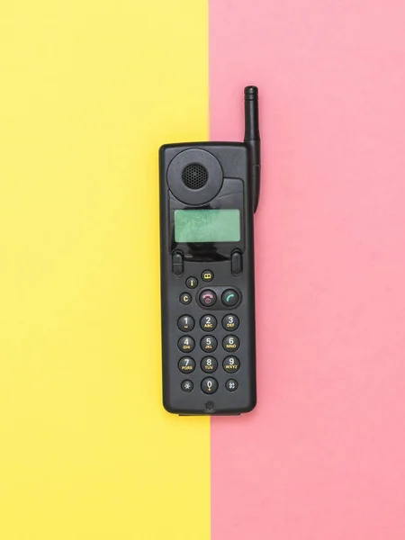 Ρετρό κινητό τηλέφωνο με κεραία σε κίτρινο και ροζ φόντο. Ρετρό μέσο επικοινωνίας. — Φωτογραφία Αρχείου