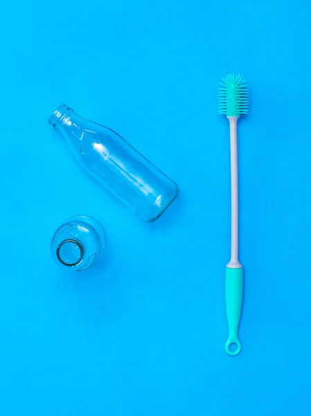 Two glass bottles and a wash brush on a blue background. — Stock Photo, Image