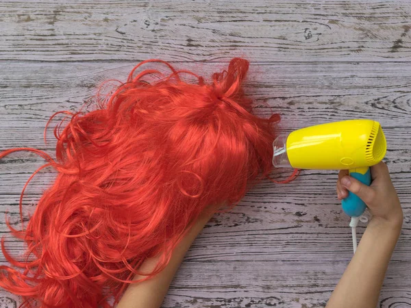 Mani per bambini asciugare arancione parrucca giallo asciugacapelli . — Foto Stock