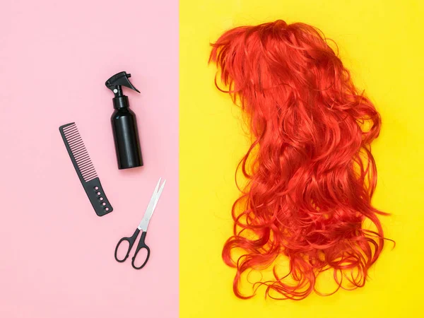 Φωτεινή πορτοκαλί περούκα και αξεσουάρ styling μαλλιών σε χρωματιστό φόντο. Αξεσουάρ για τη δημιουργία στυλ. — Φωτογραφία Αρχείου