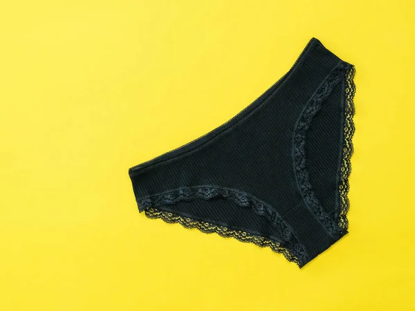 Pantalones de mujer de algodón negro sobre fondo amarillo . —  Fotos de Stock