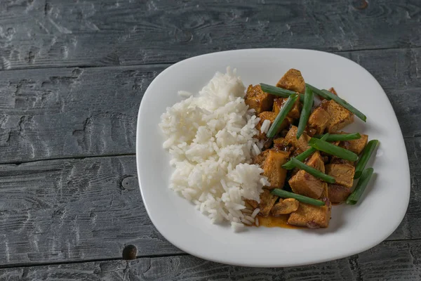 Roast tofu with rice and soy sauce on the table. Top view.