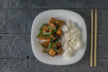 Masada pirinç ve soya sosu ile rosto tofu. Düz yatıyordu.