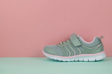 Mavi ve pembe arka plan üzerinde sol ayak ile Şık spor ayakkabı.