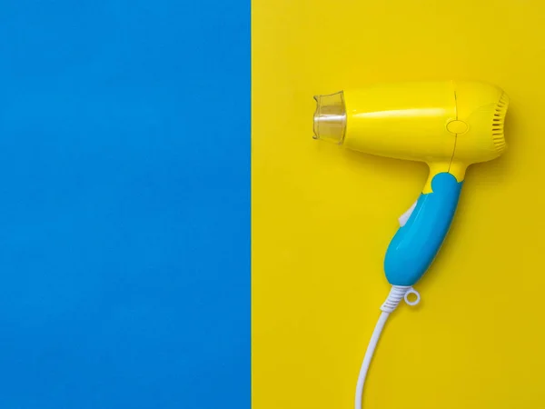 Asciugacapelli giallo-blu su sfondo giallo accanto al blu . — Foto Stock