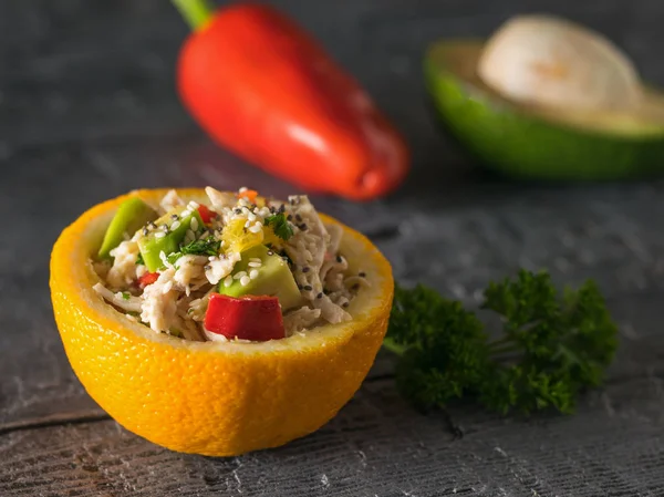 Media naranja llena de ensalada sobre fondo de pimienta y aguacate . — Foto de Stock