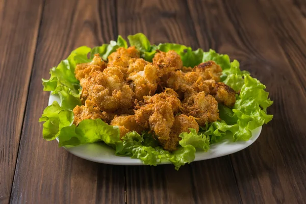 Cauliflower baked in cheese on a platter on a wooden table. The view from the top. — Stock Photo, Image