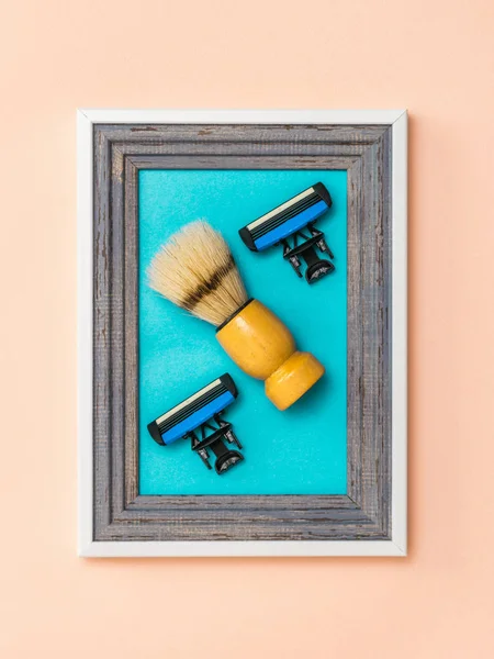 Shaving brush with two replaceable blades in a frame on a coral background. Minimalism. Modern creative creativity.