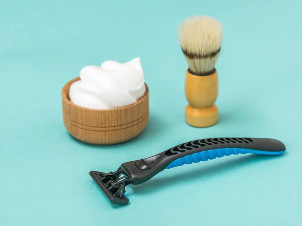 Shaving machine with shaving foam and brush on a blue background. — Stock Photo, Image