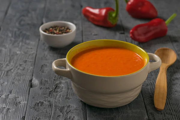 Soup mashed red bell pepper with a wooden spoon on the table. — Stock Photo, Image