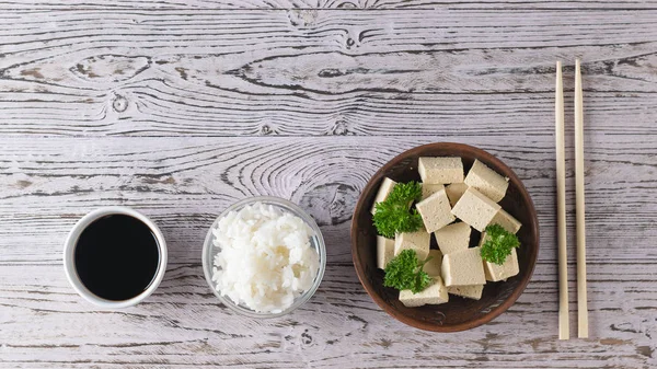 豆腐芝士配欧芹,酱油和米饭放在木桌上. 大豆芝士。 平躺着. — 图库照片