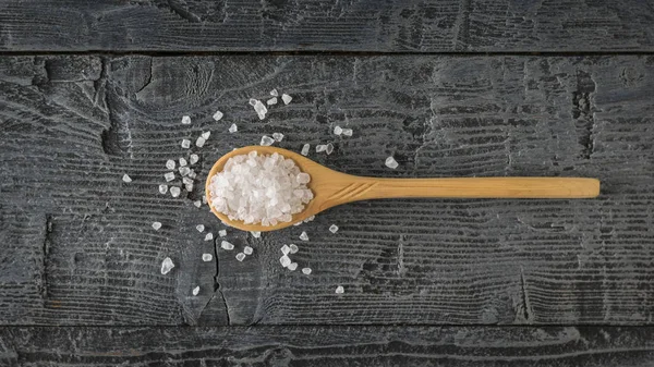 Skje av lett tre fylt med stort havsalt på et trebord. Utsikten fra toppen . – stockfoto