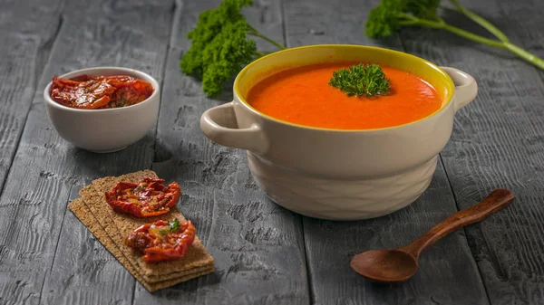 Dried tomatoes and mashed bell pepper soup on a wooden table. — Stock Photo, Image