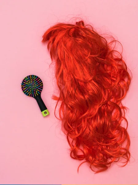 Πολύχρωμη χτένα και φωτεινή περούκα σε ροζ φόντο. Αξεσουάρ για τη δημιουργία στυλ. — Φωτογραφία Αρχείου