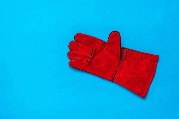 Červená pracovní rukavice na jasně modrém pozadí. — Stock fotografie