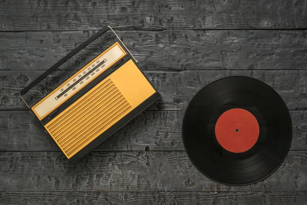 Radio retro y disco de vinilo sobre fondo de madera. Ingeniería de radio del pasado . — Foto de Stock
