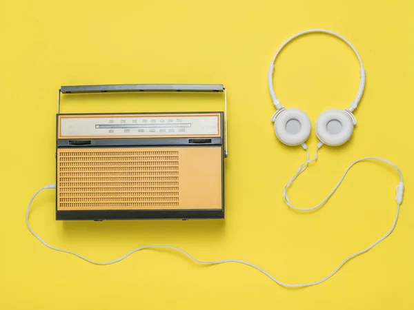 Auriculares con radio retro sobre fondo amarillo. Técnica vintage . — Foto de Stock