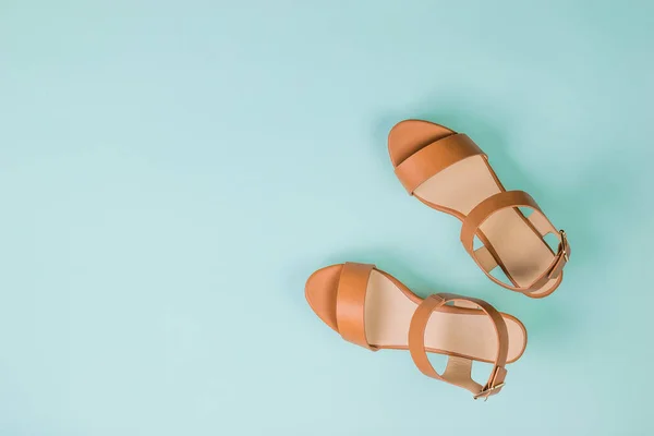 Sandálias elegantes de couro feminino em um fundo azul claro. Depósito plano . — Fotografia de Stock
