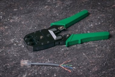 Yeşil saplı krema ve taştan bir arka planda utp kablosu.