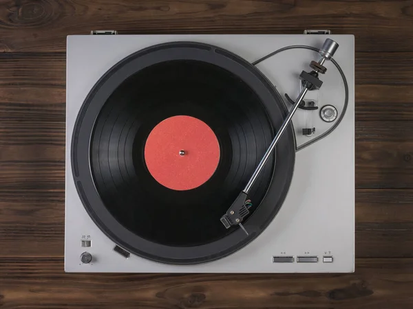 Vinyl record player on a wooden background. The view from the top. — Stock Photo, Image