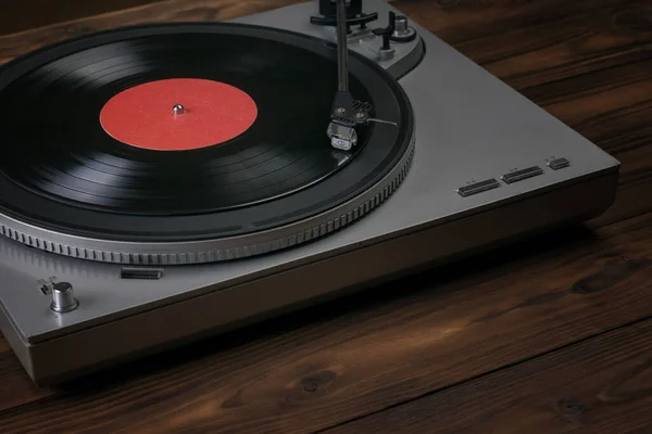 A red vinyl record player on a wooden table. — Stock Photo, Image