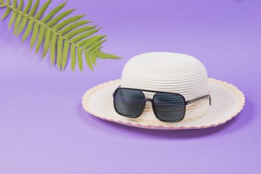 Gözlüklü güneş şapkası ve leylak arka planda bir yaprak..