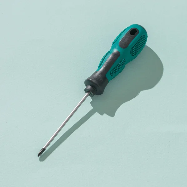 A screwdriver in hard light on a blue background. — Stock Photo, Image