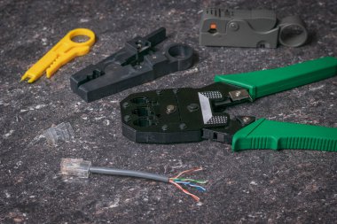 Taştan bir arkaplanda utp kablosu bağlamak için araçlar.