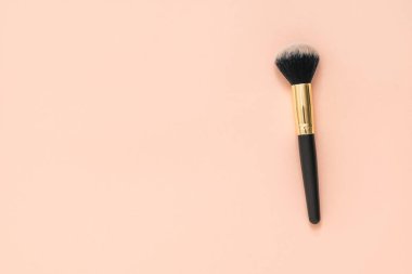 Pastel arka planda siyah beyaz tüylü makyaj fırçası.