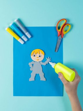 Kağıttan yapılmış bir uygulamaya bir adamın görüntüsüyle yapıştırıcı uygulamak.