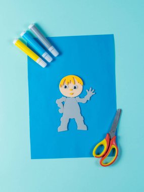 Makas, keçeli kalem ve kağıt bir erkek figürü..