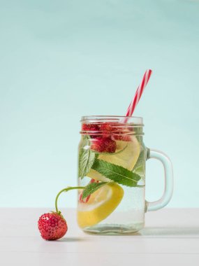 Beyaz bir masada çilek ve bir kupa soğuk içecek..