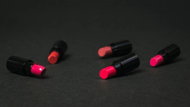 Siyah arka planda dağılmış kadın ruju örnekleri..