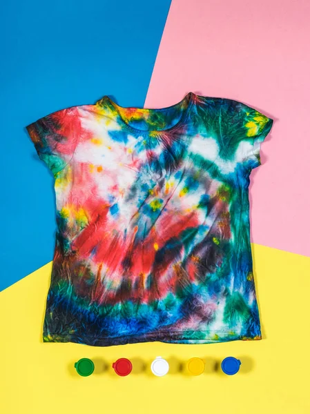 T-shirt em estilo tie dye e pintura em um fundo de três cores. Depósito plano . — Fotografia de Stock